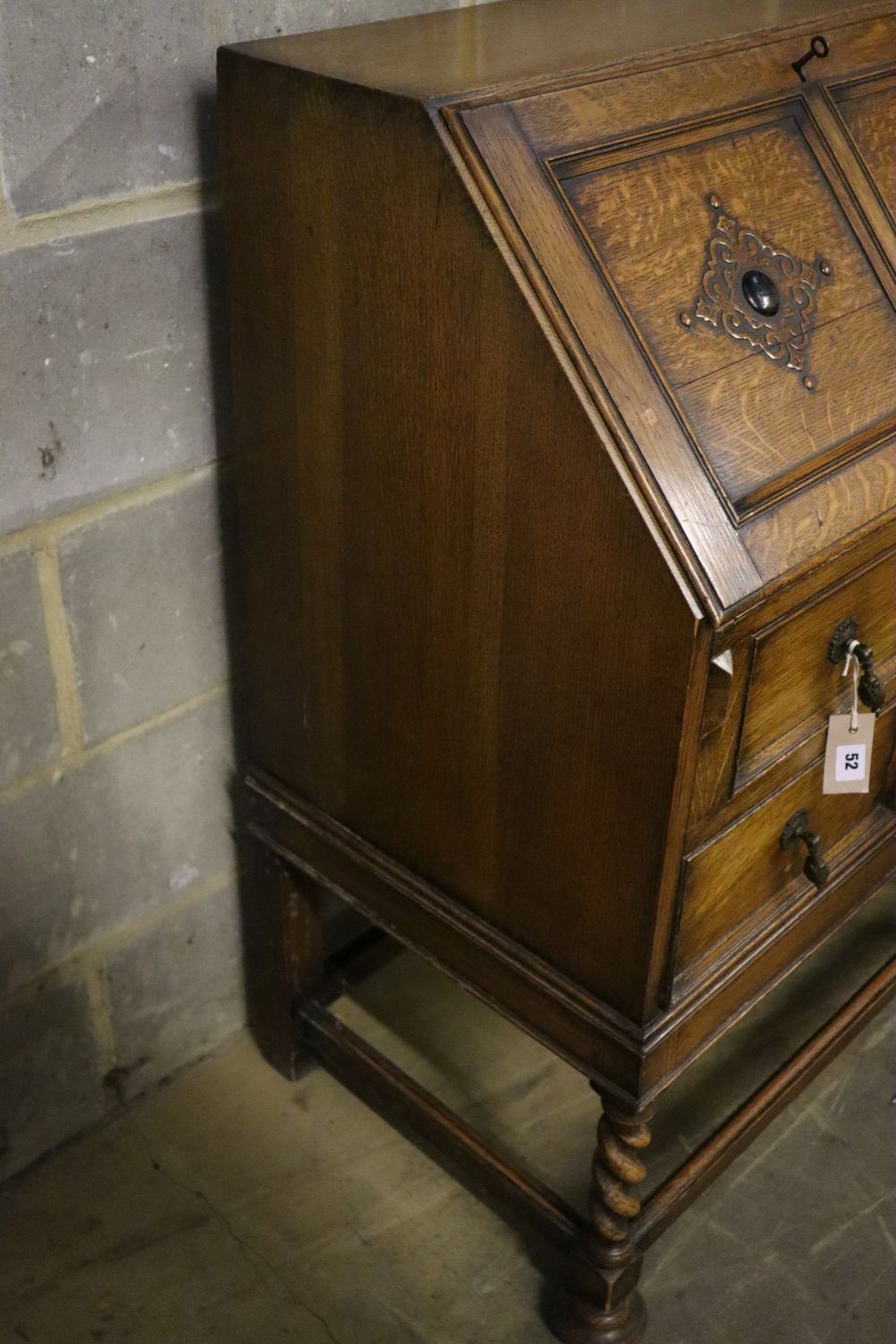 A 1920s panelled oak bureau, width 74cm, depth 46cm, height 103cm, together with a similar standing corner cabinet